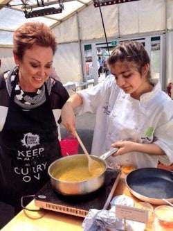 Broadcaster Christa Ackroyd gets a cooking lesson from a Queensbury student ©Rahila Hussain @RahilaHussain1