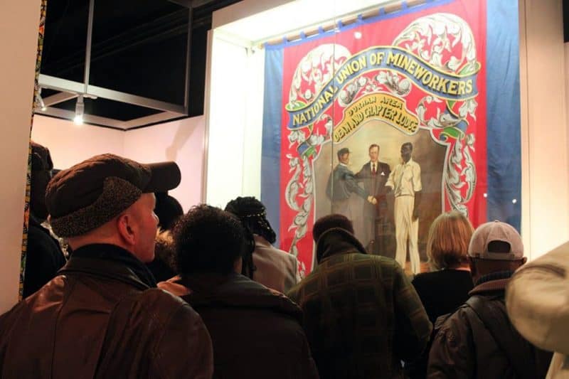 Digging Deep - Visitors look at NUM banner featuring African Caribbean mineworkers